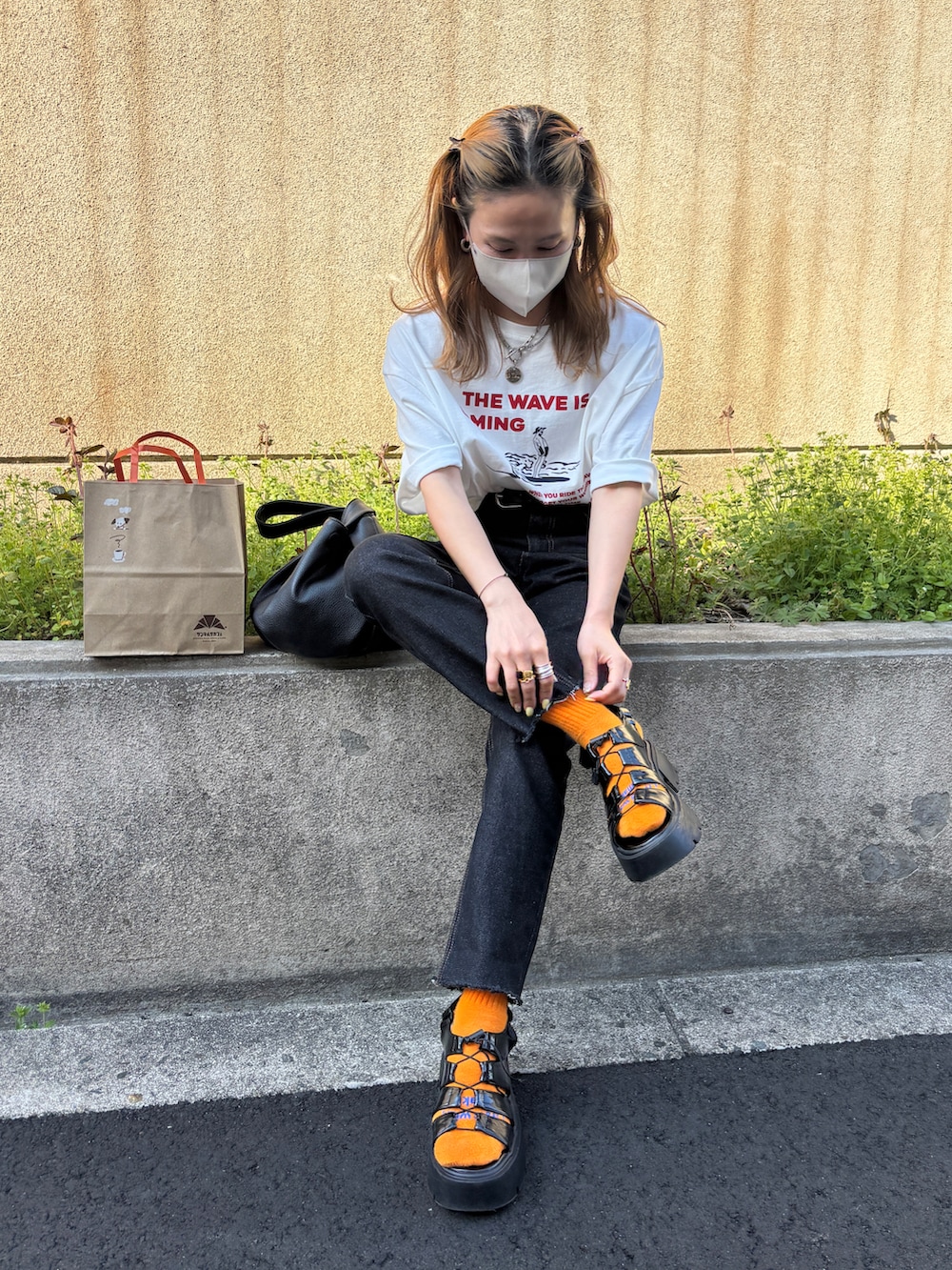 ブラック系のデニムパンツ、ホワイト系のTシャツ/カットソーを着用したレディースの春コーディネートの2枚目の写真