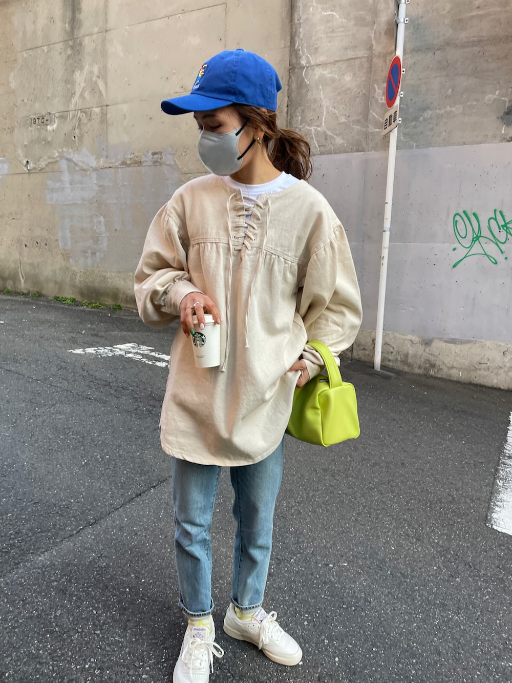 ホワイト系のスニーカー、ブルー系のデニムパンツ、ホワイト系のシャツ/ブラウスを着用したレディースの冬コーディネートの2枚目の写真