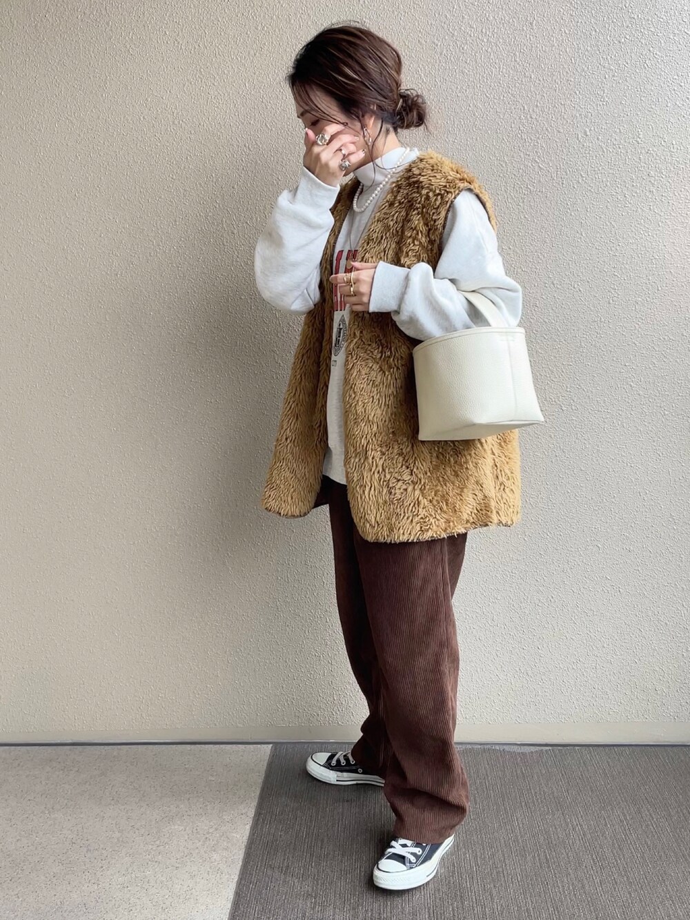 ホワイト系のノーカラージャケット、グレー系のスウェット、ブラウン系のパンツを着用したレディースの冬コーディネートの3枚目の写真