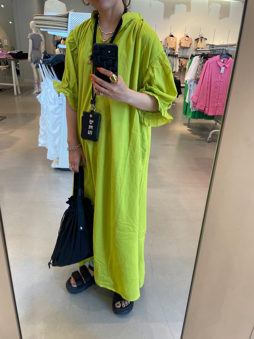 グリーン系のワンピース、ブラック系のエコバッグ/サブバッグを着用したレディースの春コーディネートの2枚目の写真