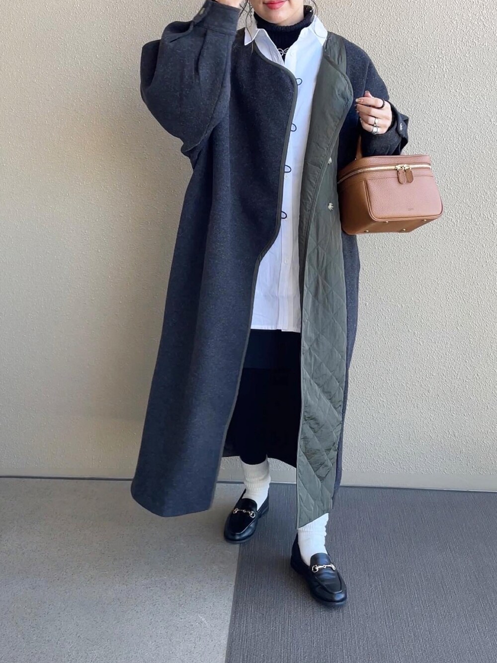 ホワイト系のシャツ/ブラウス、ブラック系のスラックス、グレー系のノーカラーコートを着用したレディースの冬コーディネートの3枚目の写真