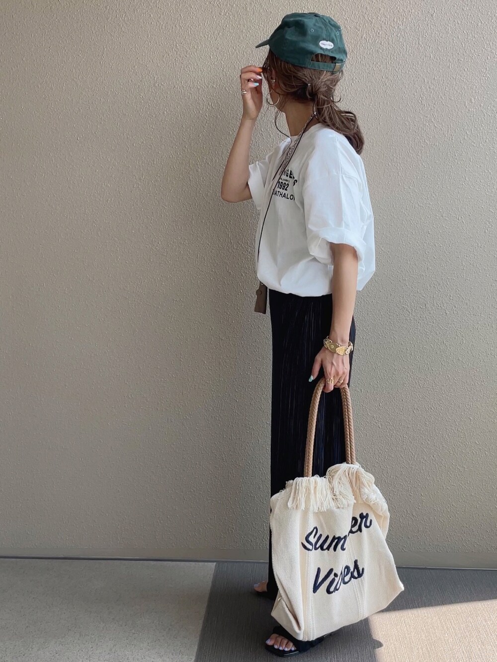 ホワイト系のTシャツ/カットソー、ホワイト系のトートバッグ、ブルー系のデニムパンツを着用したレディースの夏コーディネートの5枚目の写真