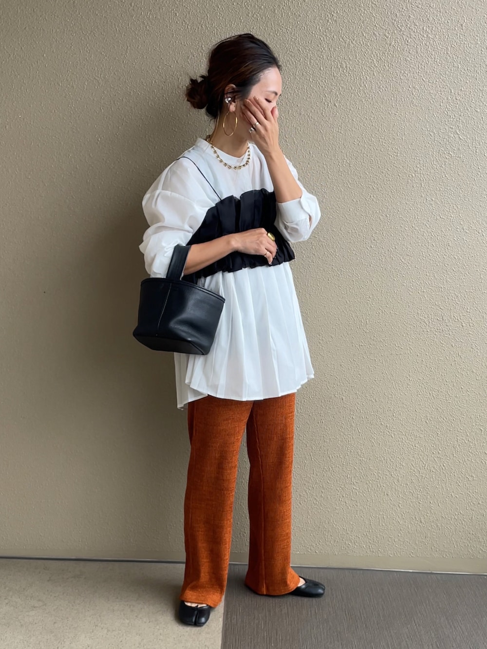 オレンジ系のその他パンツ、ホワイト系のシャツ/ブラウス、ブラック系のTシャツ/カットソーを着用したレディースの秋コーディネートの2枚目の写真