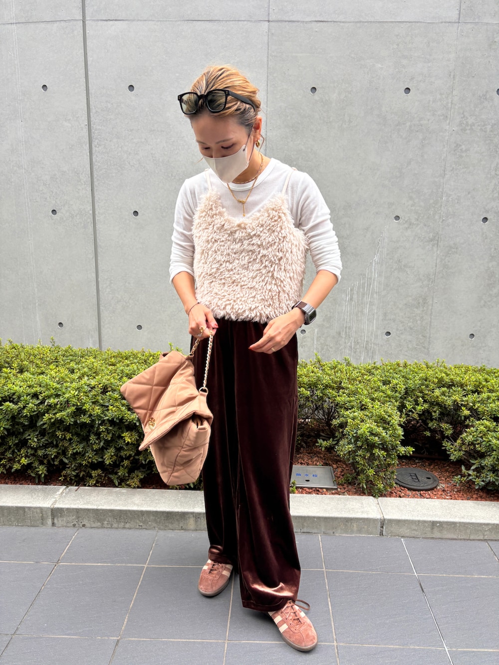 ホワイト系のベスト、ブラウン系のスニーカー、ブラウン系のパンツを着用したレディースの秋コーディネートの5枚目の写真