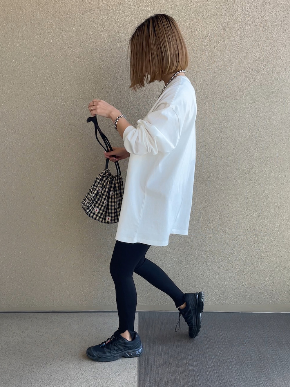 ホワイト系のTシャツ/カットソー、ブラック系のスニーカー、その他のハンドバッグを着用したレディースの春コーディネートの3枚目の写真