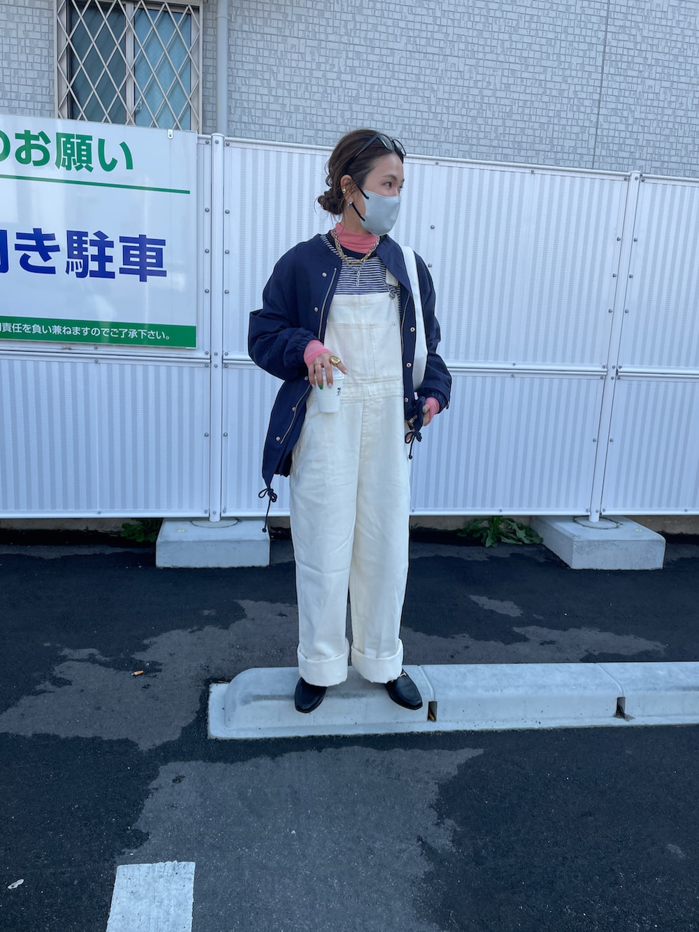 ブルー系のミリタリージャケット、ホワイト系のサロペット/オーバーオール、ホワイト系のハンドバッグを着用したレディースの春コーディネートの3枚目の写真