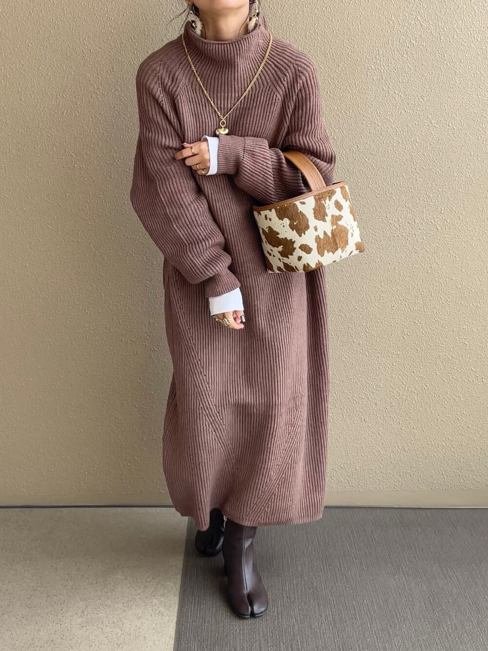 ホワイト系のダウンジャケット/コート、ブラウン系のワンピース/ドレス、ベージュ系のハンドバッグを着用したレディースの秋コーディネートの2枚目の写真