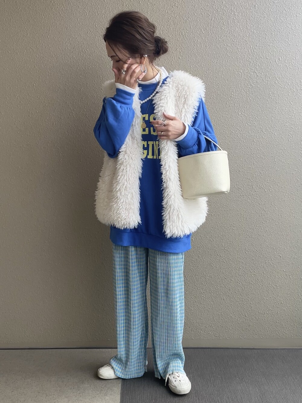 ブルー系のスウェット、ホワイト系のベスト、ブラック系のその他パンツを着用したレディースの冬コーディネートの4枚目の写真