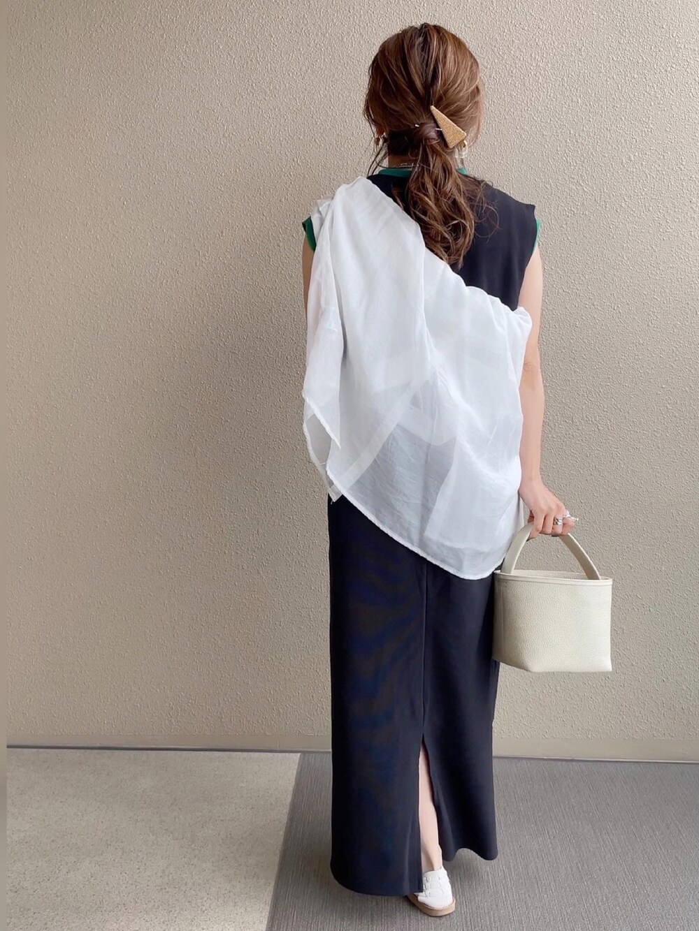 ブラック系のジャンパースカート、ホワイト系のトップス、ホワイト系のニット/セーターを着用したレディースの春コーディネートの4枚目の写真