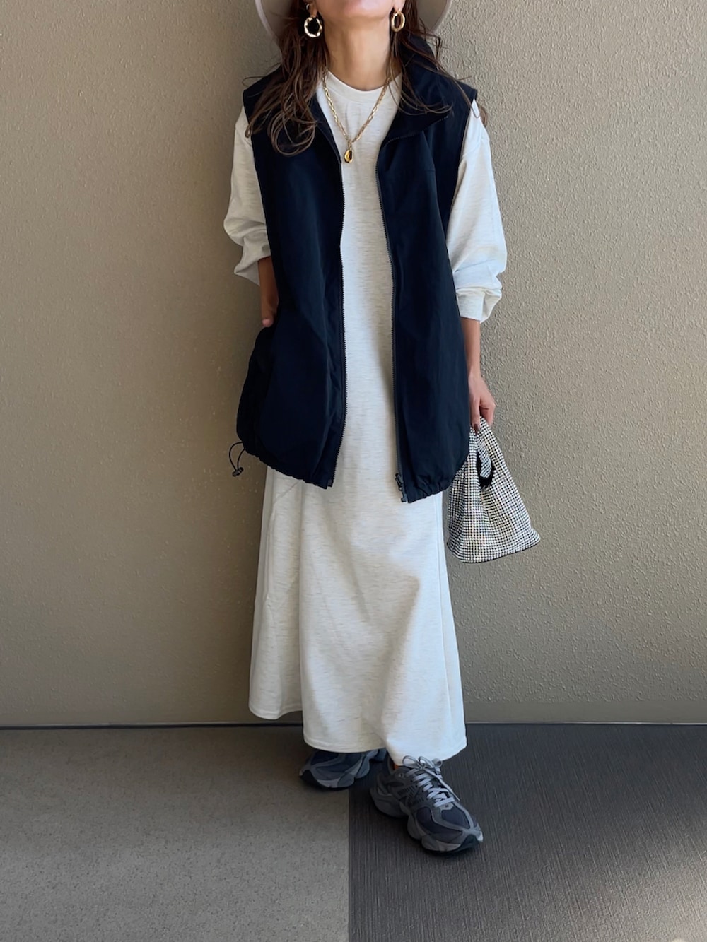 グレー系のワンピース、ブラック系のベストを着用したレディースの秋コーディネートの4枚目の写真