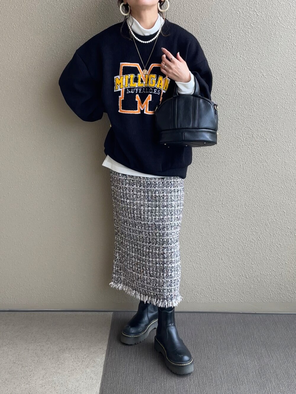 ブラック系のニット/セーター、ホワイト系のTシャツ/カットソー、ベージュ系のその他パンツを着用したレディースの冬コーディネートの2枚目の写真