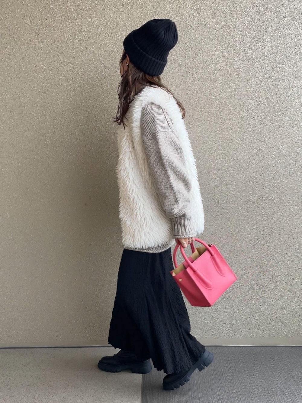 ベージュ系のニット/セーター、ブラウン系のデニムパンツ、ベージュ系のワンピースを着用したレディースの秋コーディネートの3枚目の写真