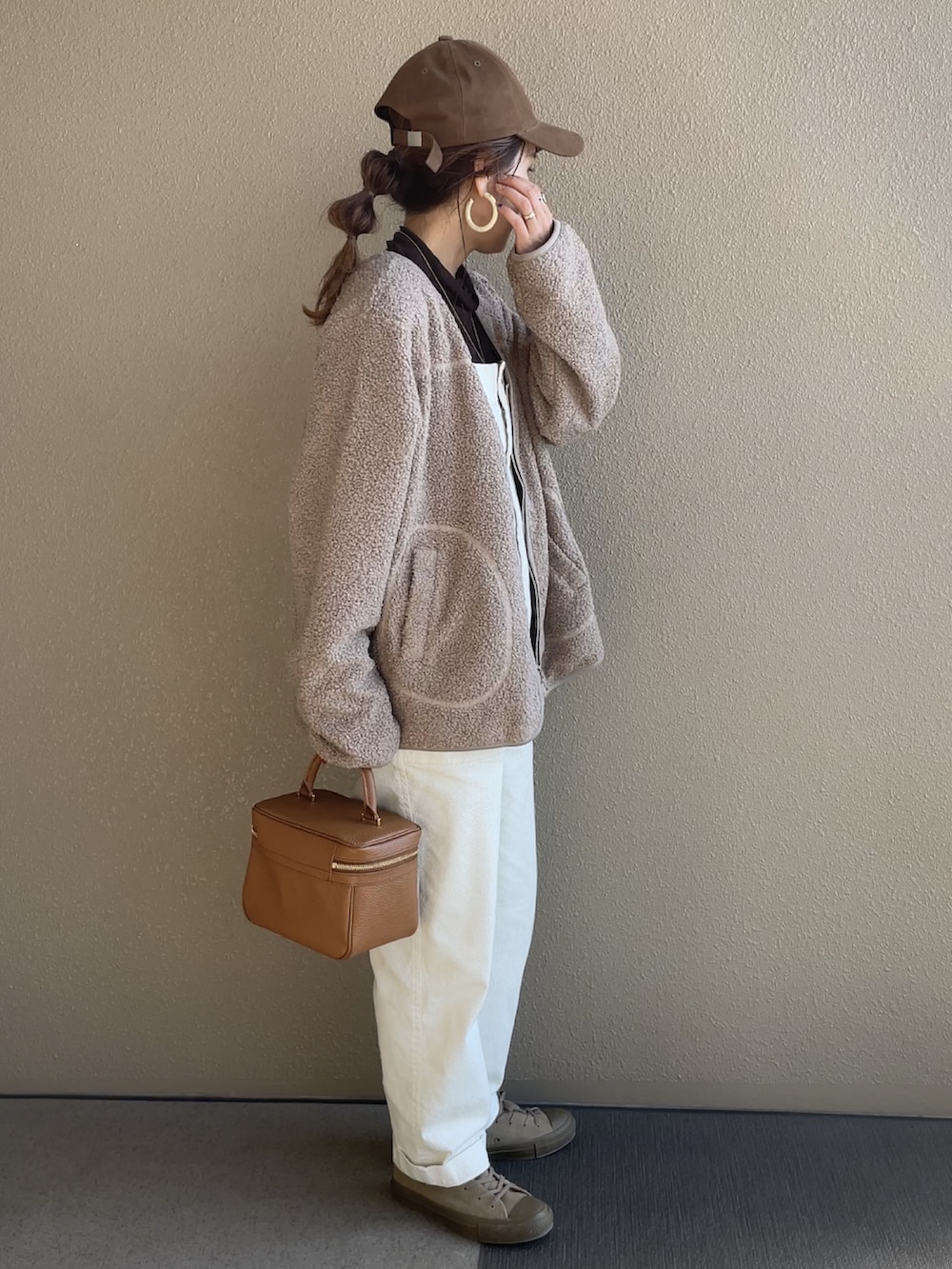 ベージュ系のダウンジャケット/コート、ホワイト系のサロペット/オーバーオール、ベージュ系のスニーカーを着用したレディースの秋コーディネートの2枚目の写真