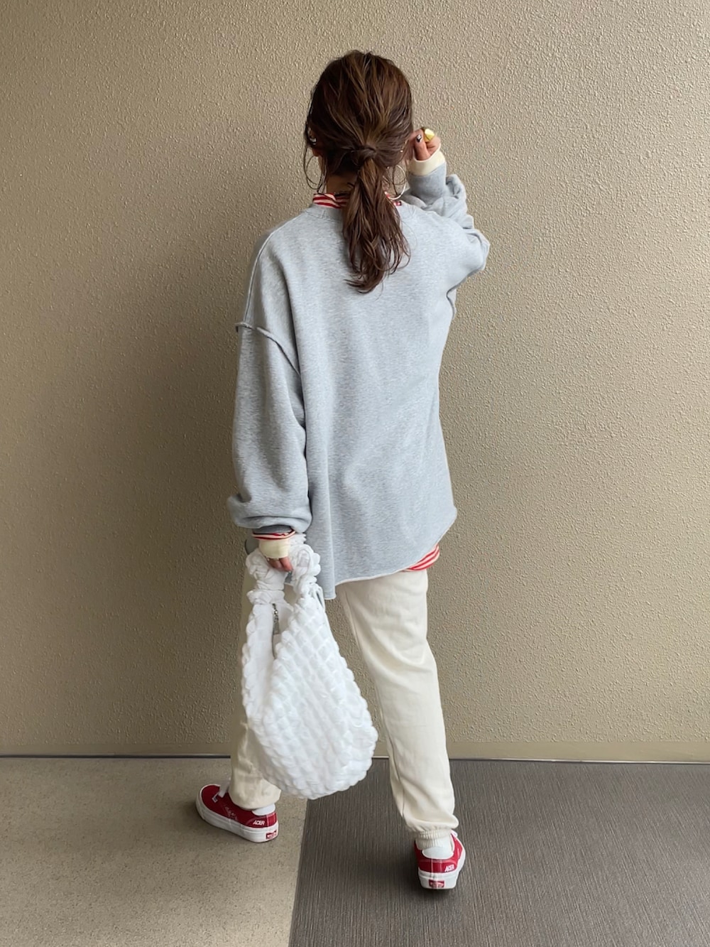 グレー系のスウェット、ベージュ系のTシャツ/カットソー、レッド系のスニーカーを着用したレディースの冬コーディネートの2枚目の写真