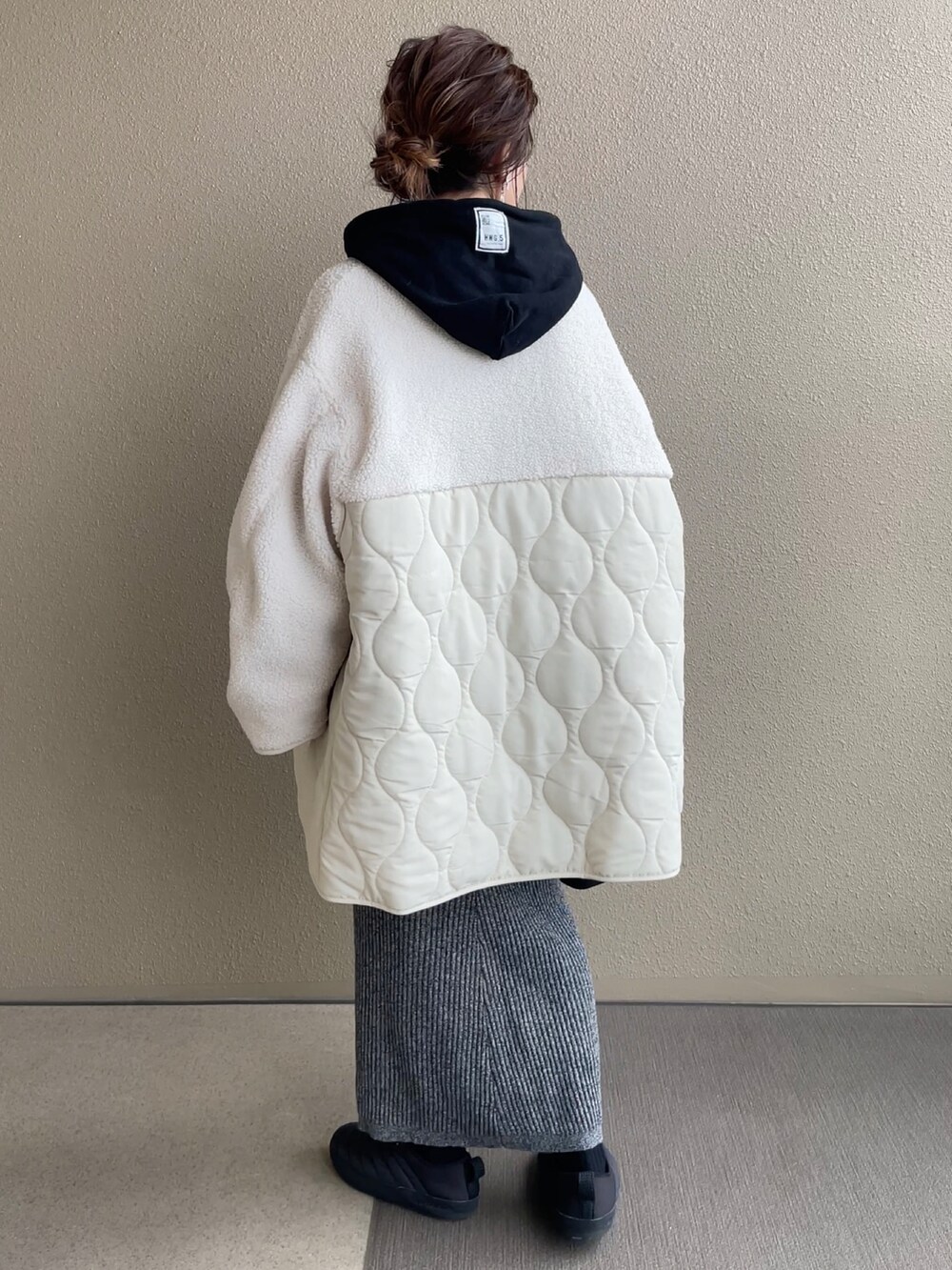 ホワイト系のノーカラージャケット、グリーン系のノーカラージャケット、ブラック系のスカートを着用したレディースの冬コーディネートの2枚目の写真