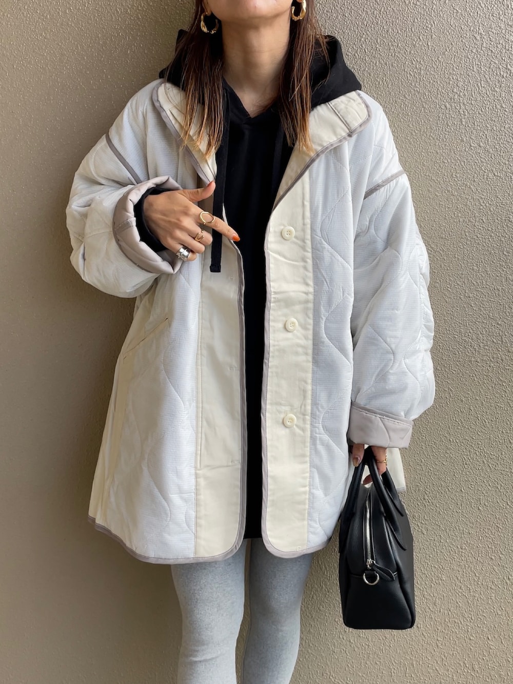 ホワイト系のその他アウター、ブラック系のパーカー、ブラック系のボストンバッグを着用したレディースの秋コーディネートの2枚目の写真