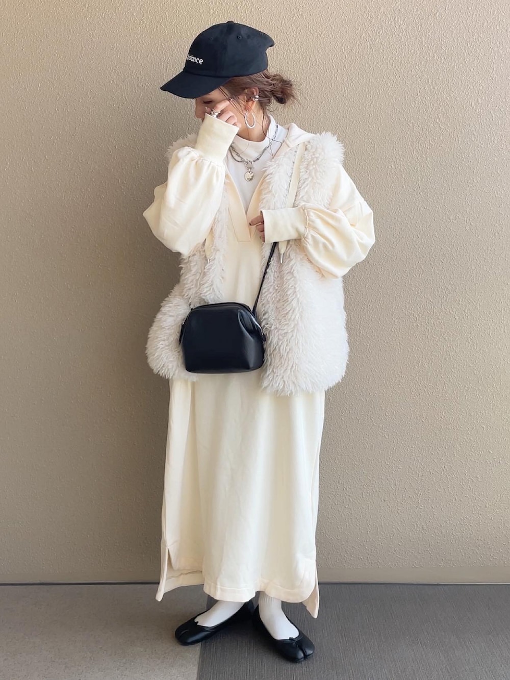 ホワイト系のワンピース、ホワイト系のベスト、グレー系のショルダーバッグを着用したレディースの冬コーディネートの4枚目の写真