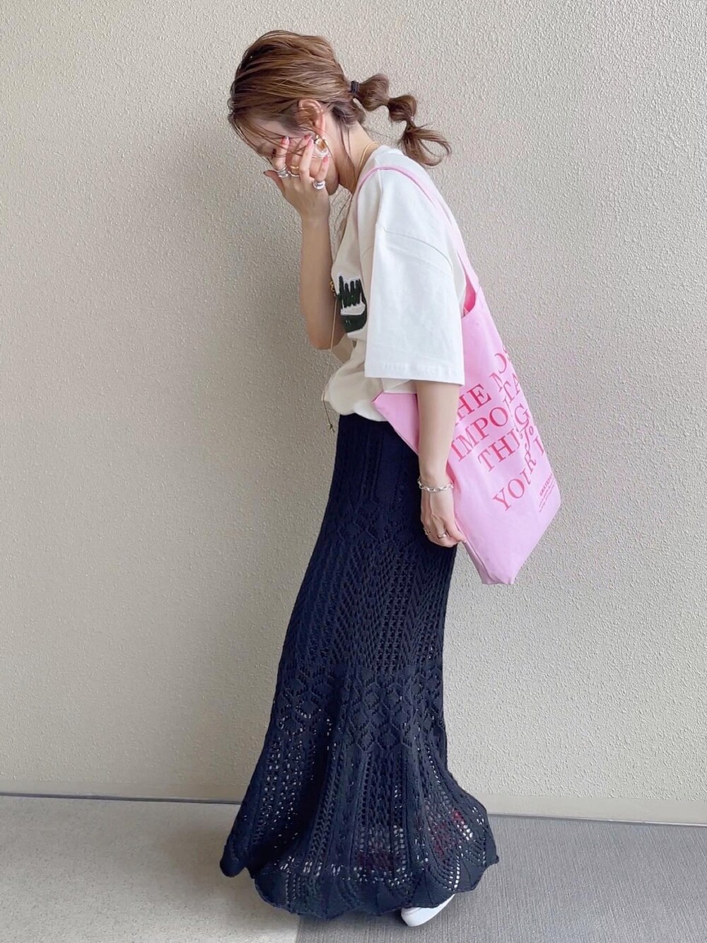 ベージュ系のTシャツ/カットソー、ブラック系のスカート、ピンク系のトートバッグを着用したレディースの春コーディネートの2枚目の写真