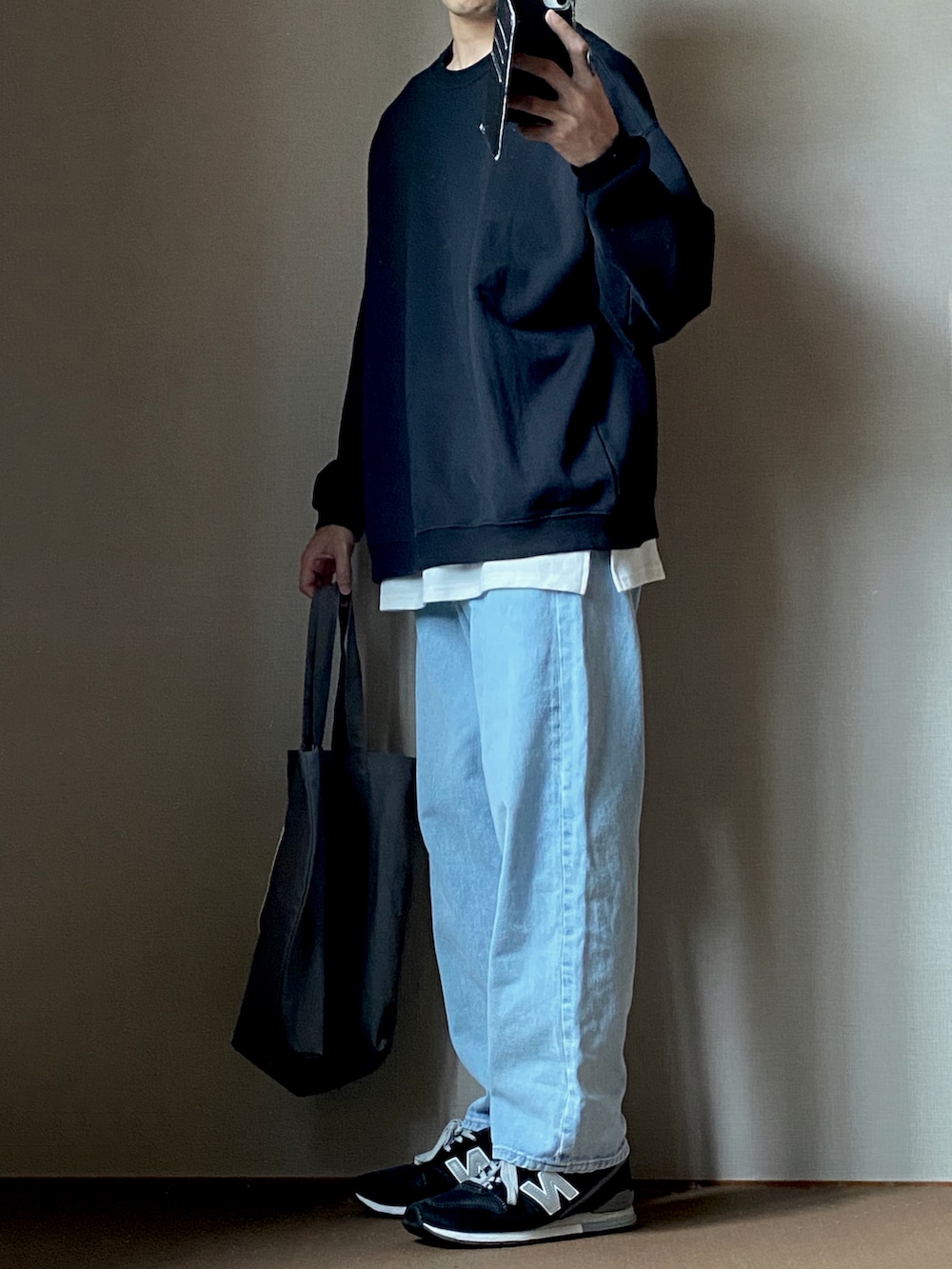 ブラック系のスウェット、ホワイト系のタンクトップ、ブルー系のデニムパンツを着用したメンズの秋コーディネートの2枚目の写真