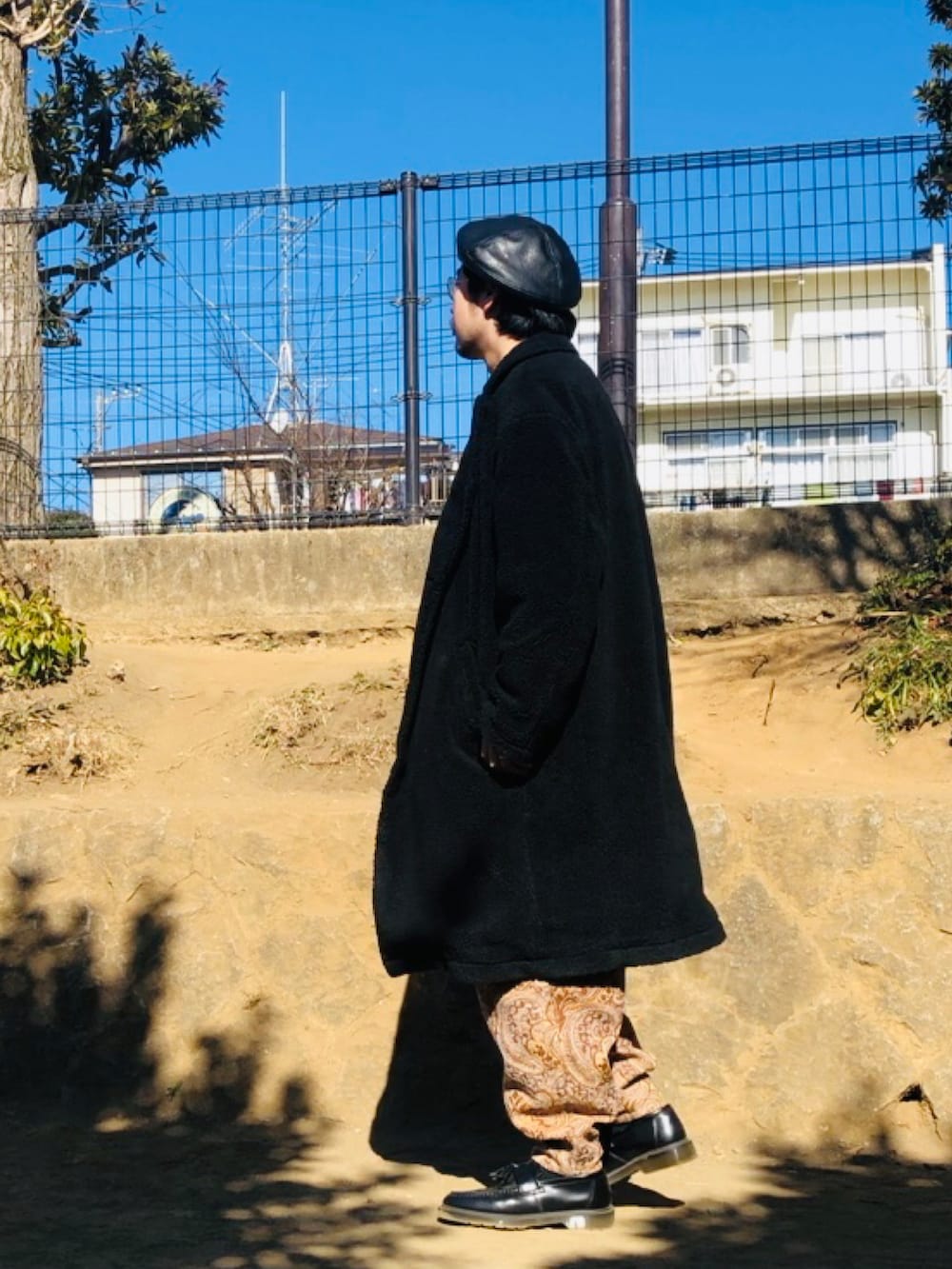 ブラック系のニット/セーター、ベージュ系のその他パンツ、ブラック系のその他アウターを着用したメンズの冬コーディネートの3枚目の写真