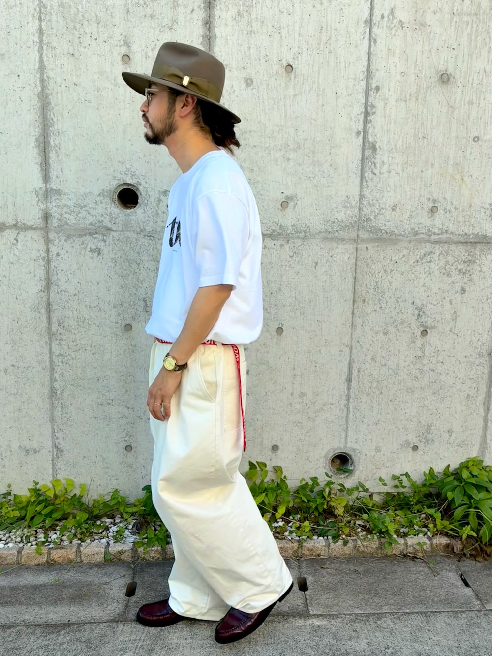 ホワイト系のTシャツ/カットソー、ホワイト系のチノパンツ、レッド系のローファーを着用したメンズの夏コーディネートの2枚目の写真