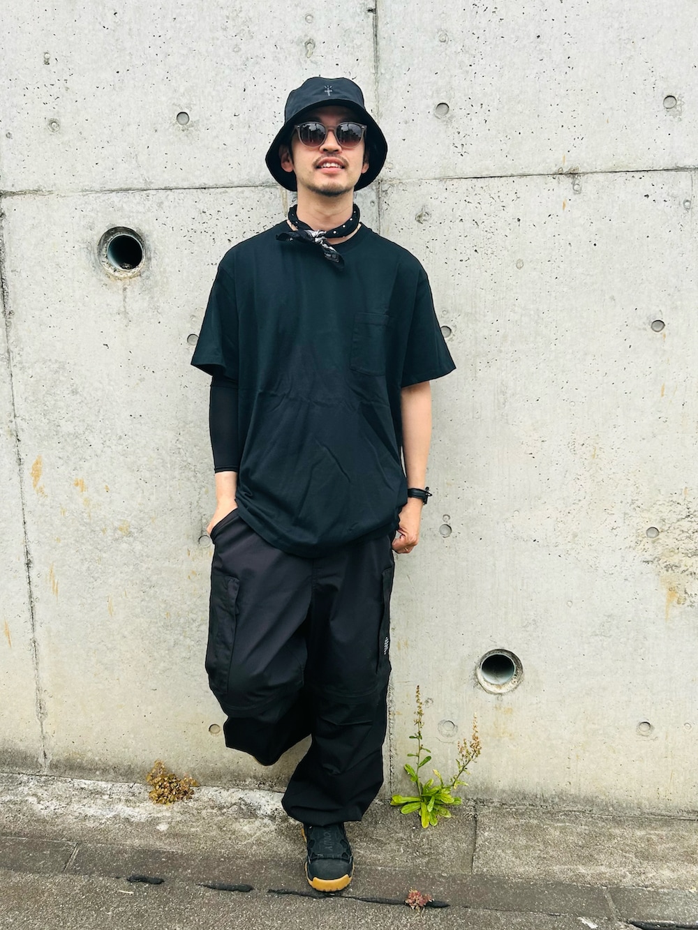 ブラック系のTシャツ/カットソー、ブラック系のカーゴパンツ、ブラック系のスニーカーを着用したメンズの夏コーディネートの2枚目の写真