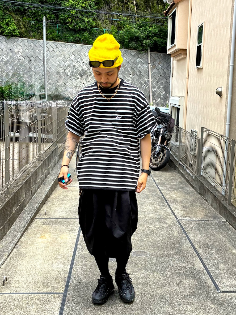 ブラック系のTシャツ/カットソー、ブラック系のその他パンツ、ブラック系のスニーカーを着用したメンズの春コーディネートの2枚目の写真