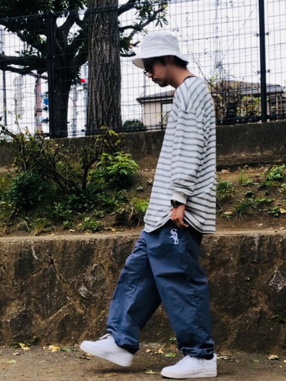 ホワイト系のTシャツ/カットソー、ブルー系のその他パンツ、ホワイト系のスニーカーを着用したメンズの秋コーディネートの4枚目の写真