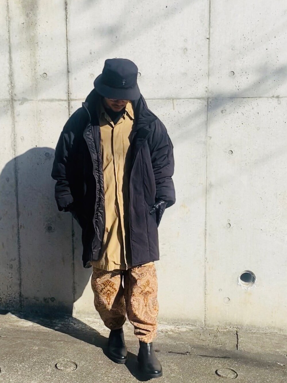 ベージュ系のジャケット/アウター、ベージュ系のその他パンツ、ブラック系のミリタリージャケットを着用したメンズの冬コーディネートの2枚目の写真