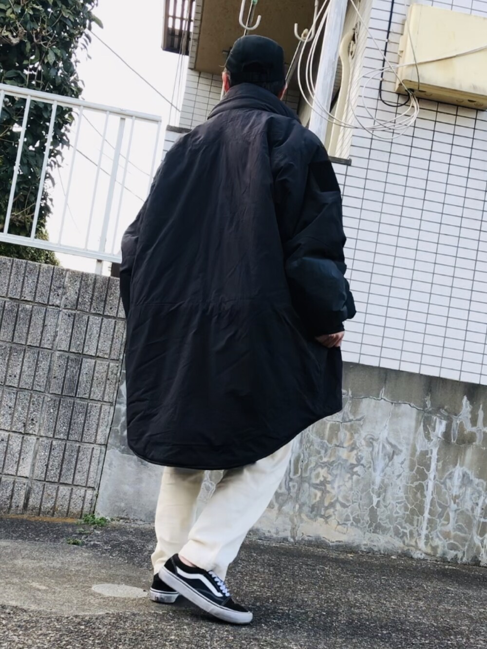 ブラック系のミリタリージャケット、ホワイト系のその他パンツ、ブラック系のスニーカーを着用したメンズの春コーディネートの3枚目の写真