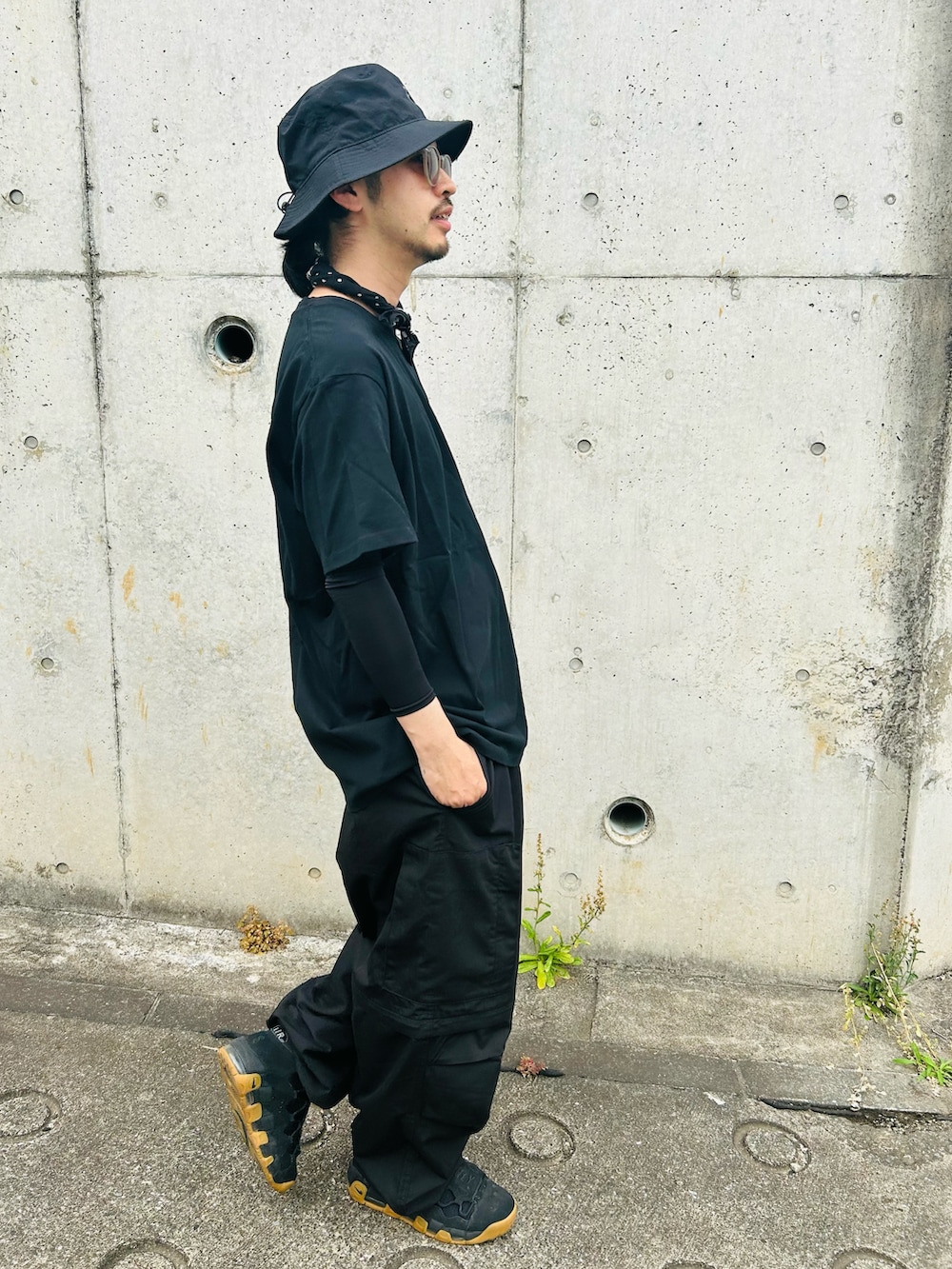 ブラック系のTシャツ/カットソー、ブラック系のカーゴパンツ、ブラック系のスニーカーを着用したメンズの夏コーディネートの3枚目の写真