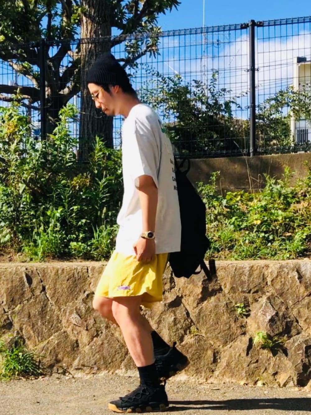 グレー系のTシャツ/カットソー、ブラック系のバックパック/リュック、ブラック系のソックス/靴下を着用したメンズの夏コーディネートの2枚目の写真