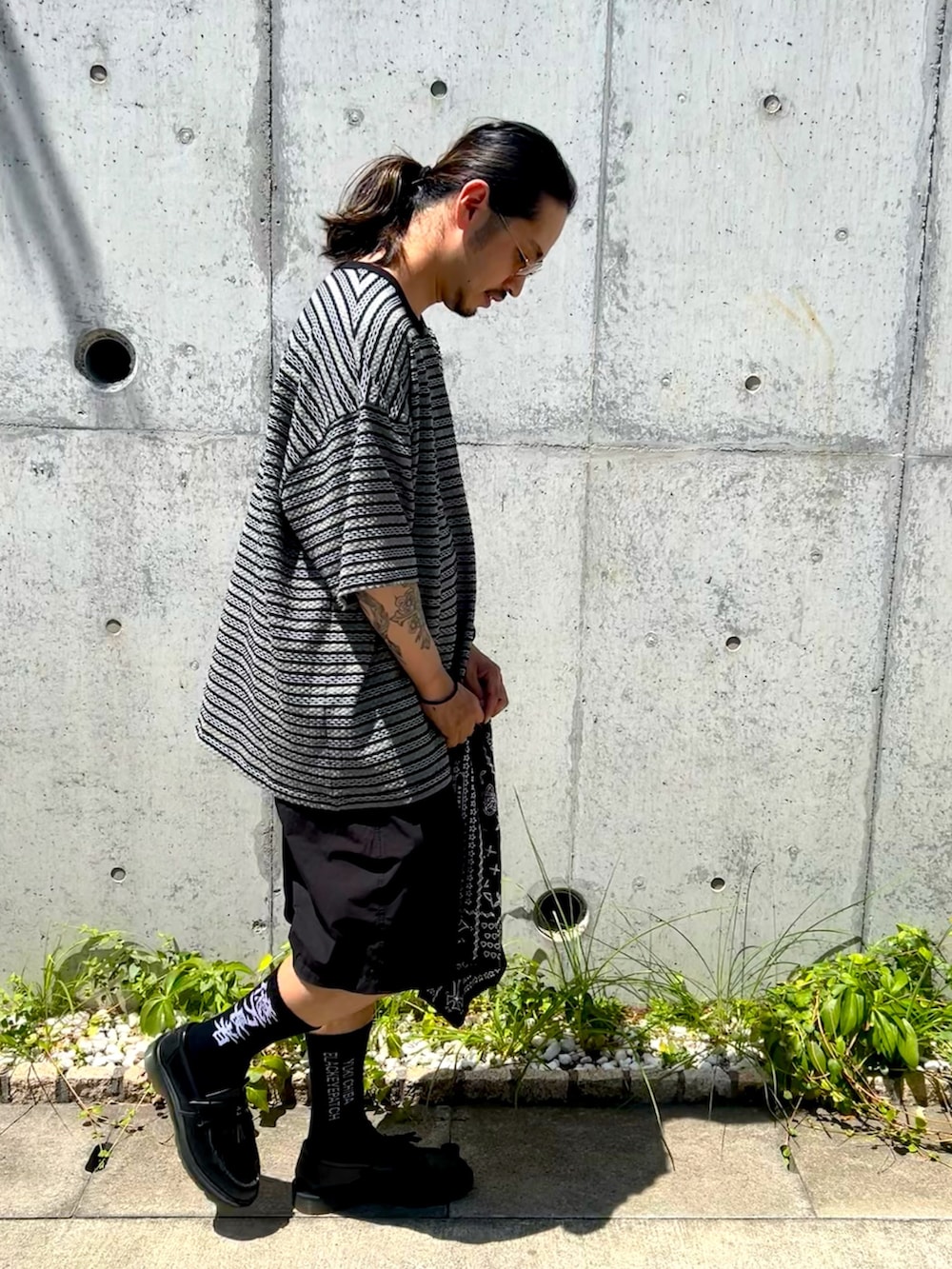 ブラック系のTシャツ/カットソー、ブラック系のパンツ、ブラック系のハットを着用したメンズの夏コーディネートの4枚目の写真