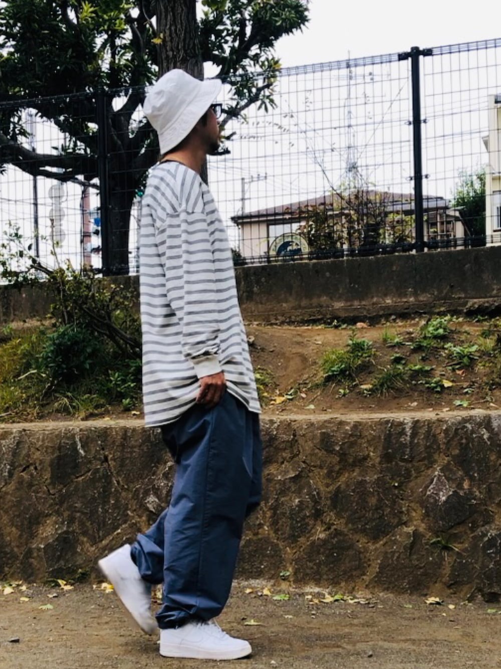 ホワイト系のTシャツ/カットソー、ブルー系のその他パンツ、ホワイト系のスニーカーを着用したメンズの秋コーディネートの2枚目の写真