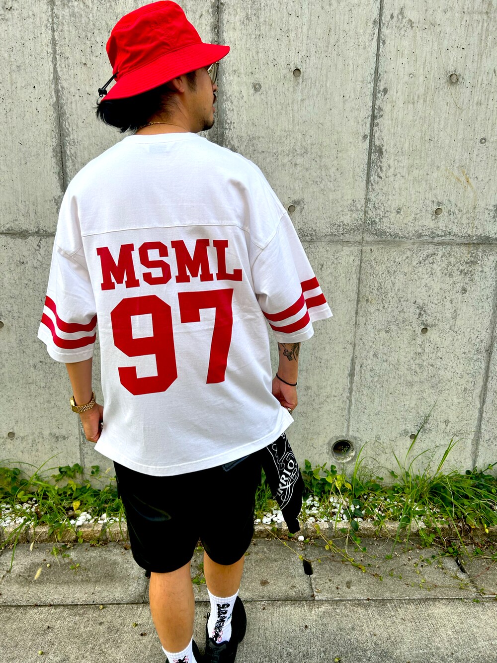 ブラック系のスニーカー、ホワイト系のTシャツ/カットソー、レッド系のハットを着用したメンズの秋コーディネートの3枚目の写真