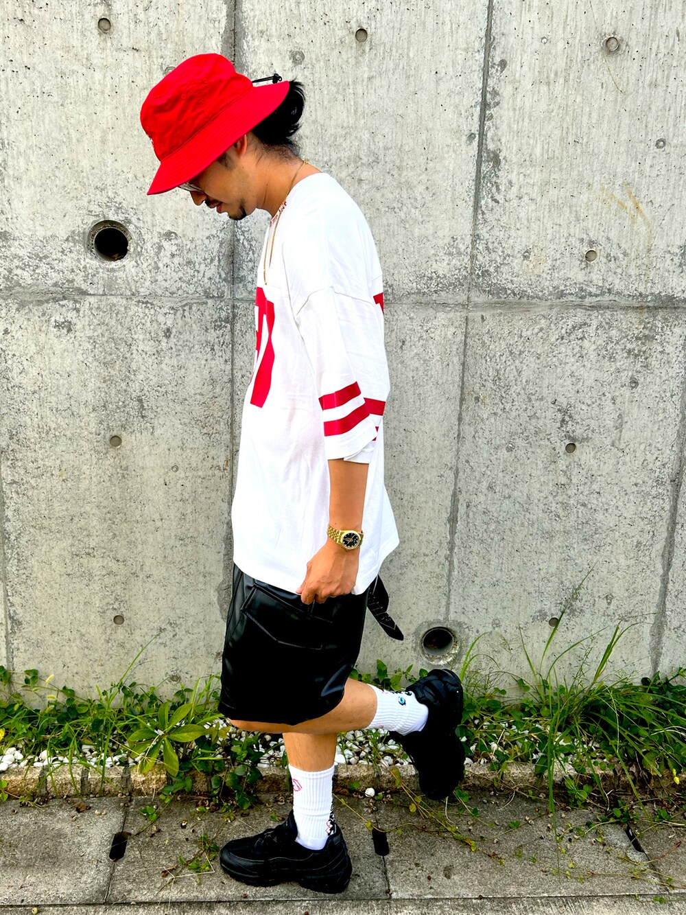 ブラック系のスニーカー、ホワイト系のTシャツ/カットソー、レッド系のハットを着用したメンズの秋コーディネートの2枚目の写真