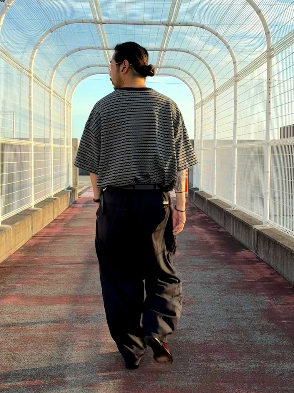 ブラック系のTシャツ/カットソー、ブラック系のスラックス、レッド系のローファーを着用したメンズの夏コーディネートの2枚目の写真