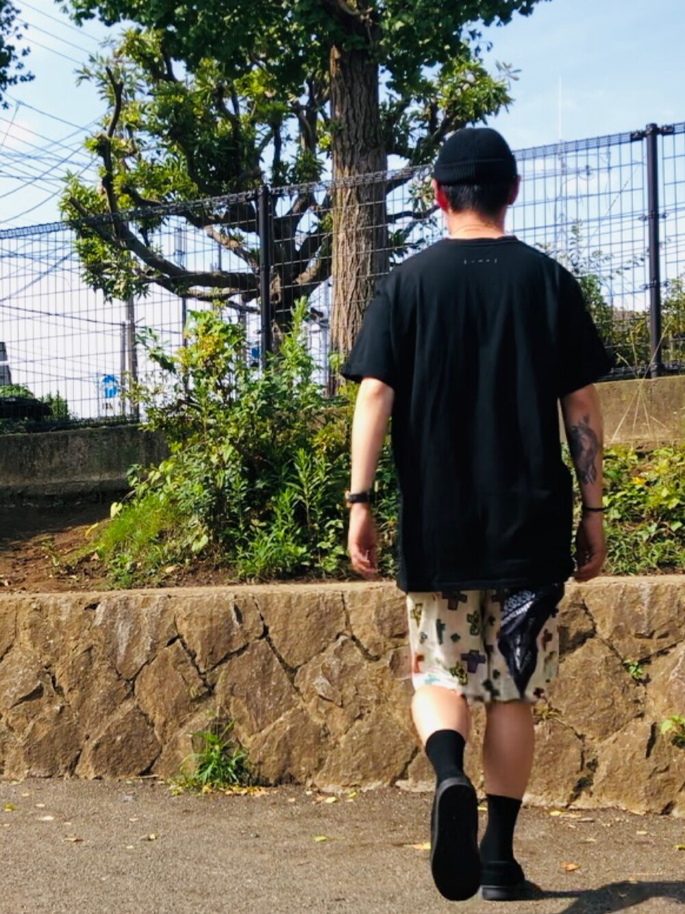 ブラック系のTシャツ/カットソー、ホワイト系のその他パンツ、ブラック系のローファーを着用したメンズの夏コーディネートの4枚目の写真