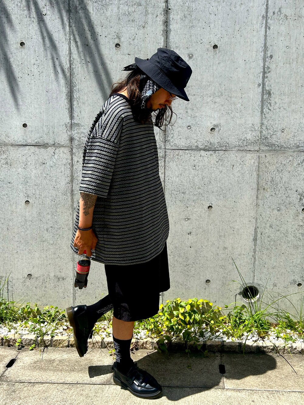 ブラック系のTシャツ/カットソー、ブラック系のパンツ、ブラック系のハットを着用したメンズの夏コーディネートの2枚目の写真