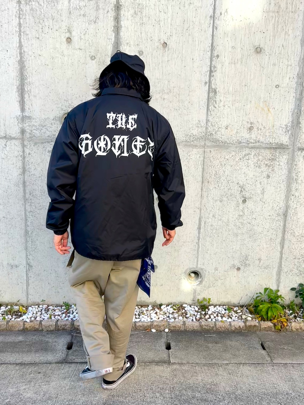 ブラック系のスニーカー、ベージュ系のチノパンツ、ブラック系のジャケット/アウターを着用したメンズの冬コーディネートの3枚目の写真