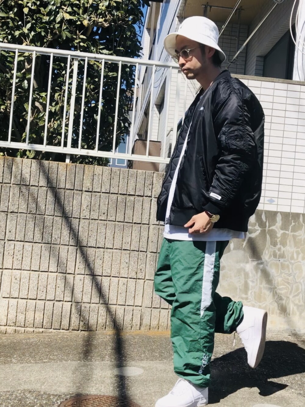 ブラック系のMA-1、グリーン系のその他パンツ、ホワイト系のスニーカーを着用したメンズの春コーディネートの3枚目の写真