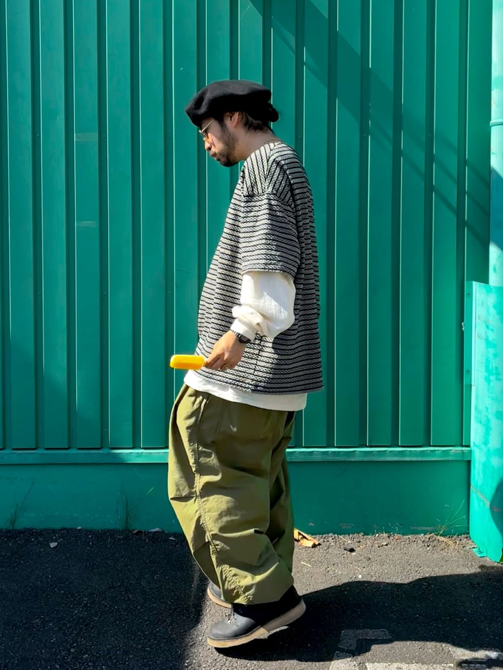 ベージュ系のTシャツ/カットソー、ブラック系のTシャツ/カットソー、グリーン系のカーゴパンツを着用したメンズの秋コーディネートの2枚目の写真