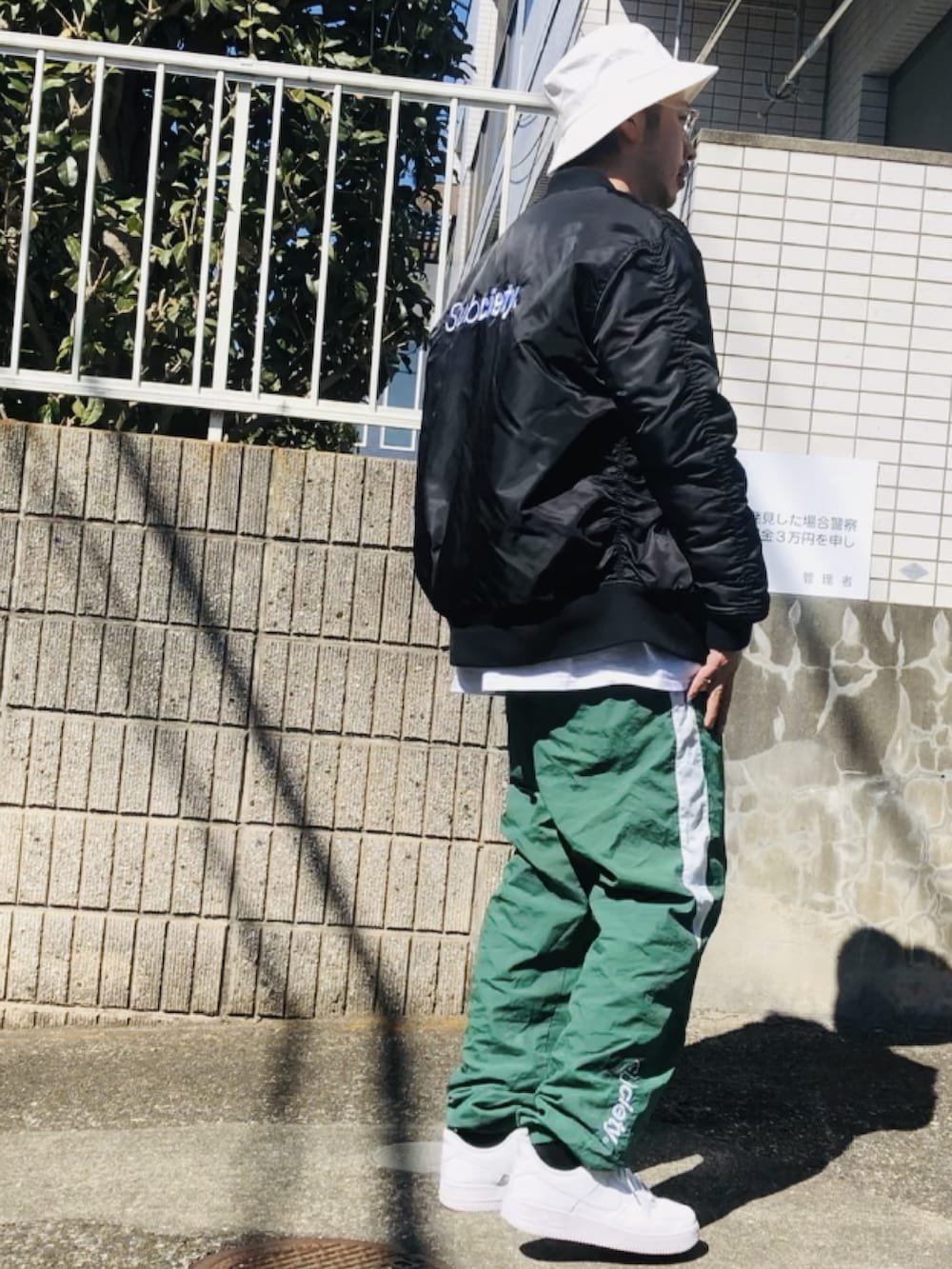 ブラック系のMA-1、グリーン系のその他パンツ、ホワイト系のスニーカーを着用したメンズの春コーディネートの2枚目の写真