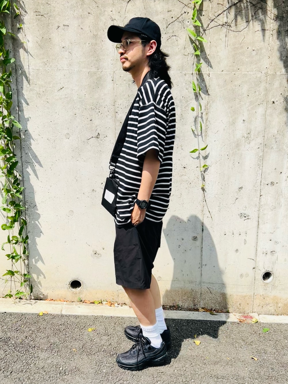 ブラック系のTシャツ/カットソー、ブラック系のパンツ、ブラック系のスニーカーを着用したメンズの夏コーディネートの4枚目の写真