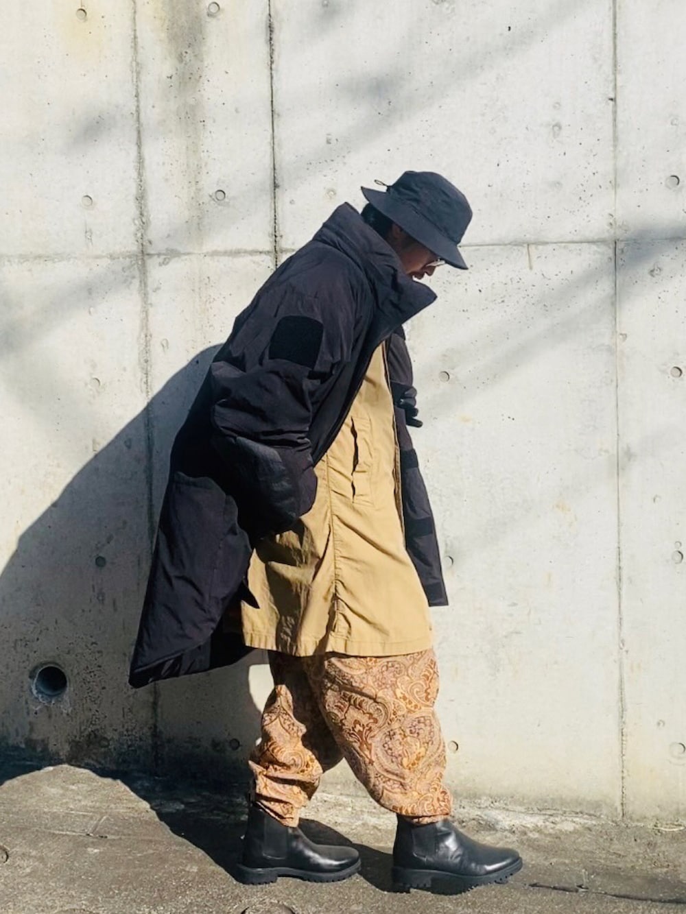 ベージュ系のジャケット/アウター、ベージュ系のその他パンツ、ブラック系のミリタリージャケットを着用したメンズの冬コーディネートの3枚目の写真