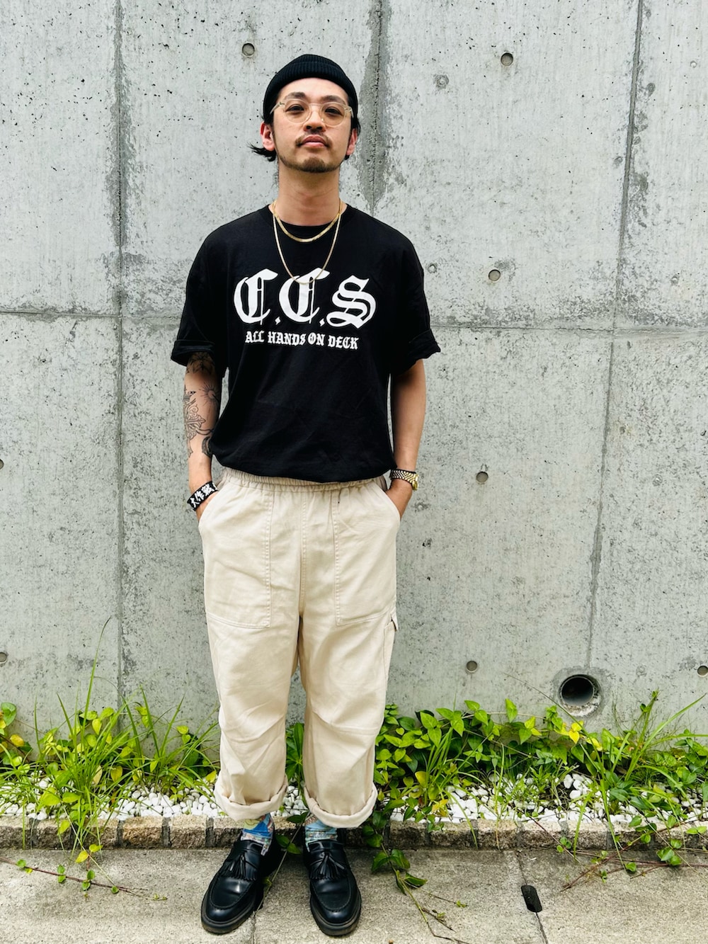 ブラック系のローファー、ホワイト系のカーゴパンツ、ブラック系のTシャツ/カットソーを着用したメンズの夏コーディネートの3枚目の写真
