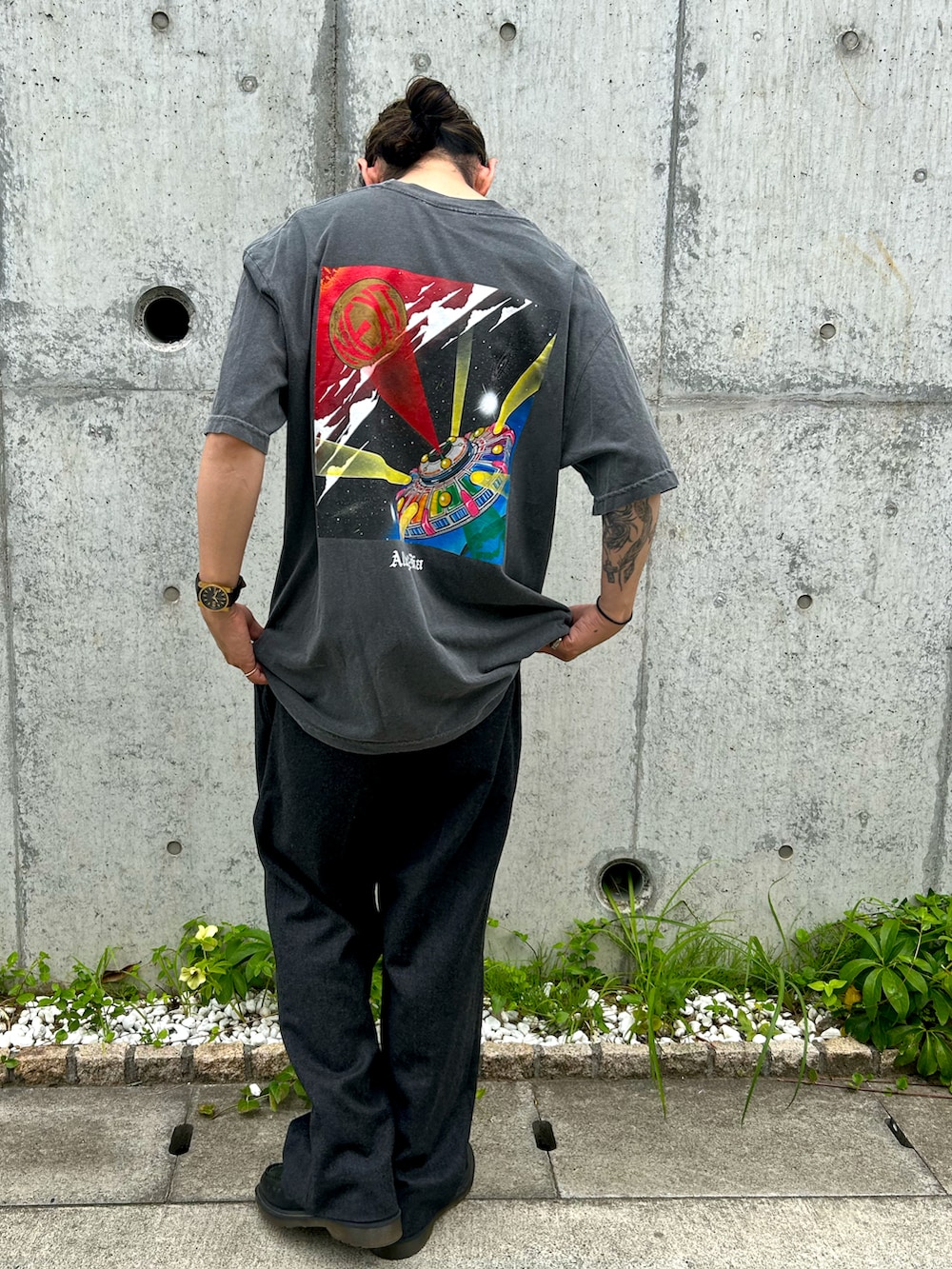 ブラック系のTシャツ/カットソー、グレー系のスラックス、ブラック系のローファーを着用したメンズの夏コーディネートの2枚目の写真