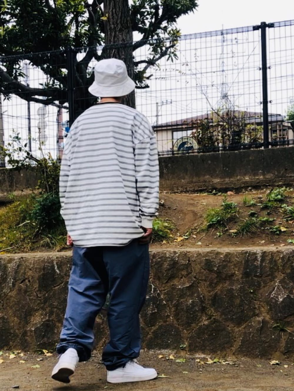 ホワイト系のTシャツ/カットソー、ブルー系のその他パンツ、ホワイト系のスニーカーを着用したメンズの秋コーディネートの3枚目の写真