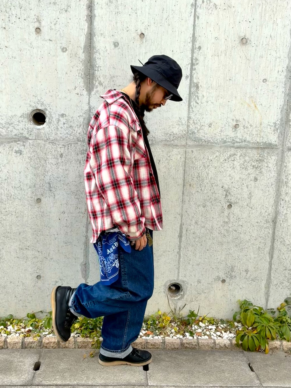 レッド系のブルゾン、ブルー系のデニムパンツ、ブラック系のブーツを着用したメンズの冬コーディネートの3枚目の写真