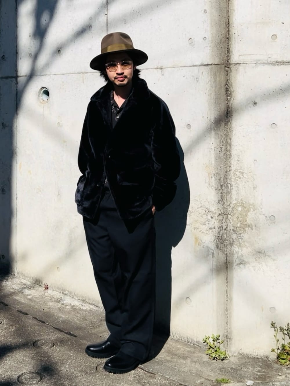 ブラック系のジャケット/アウター、ブラック系のその他パンツ、ベージュ系のハットを着用したメンズの春コーディネートの2枚目の写真
